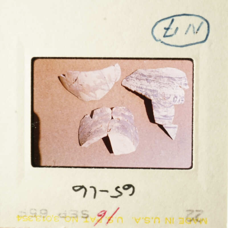 The image shows three broken pottery pieces on a table.