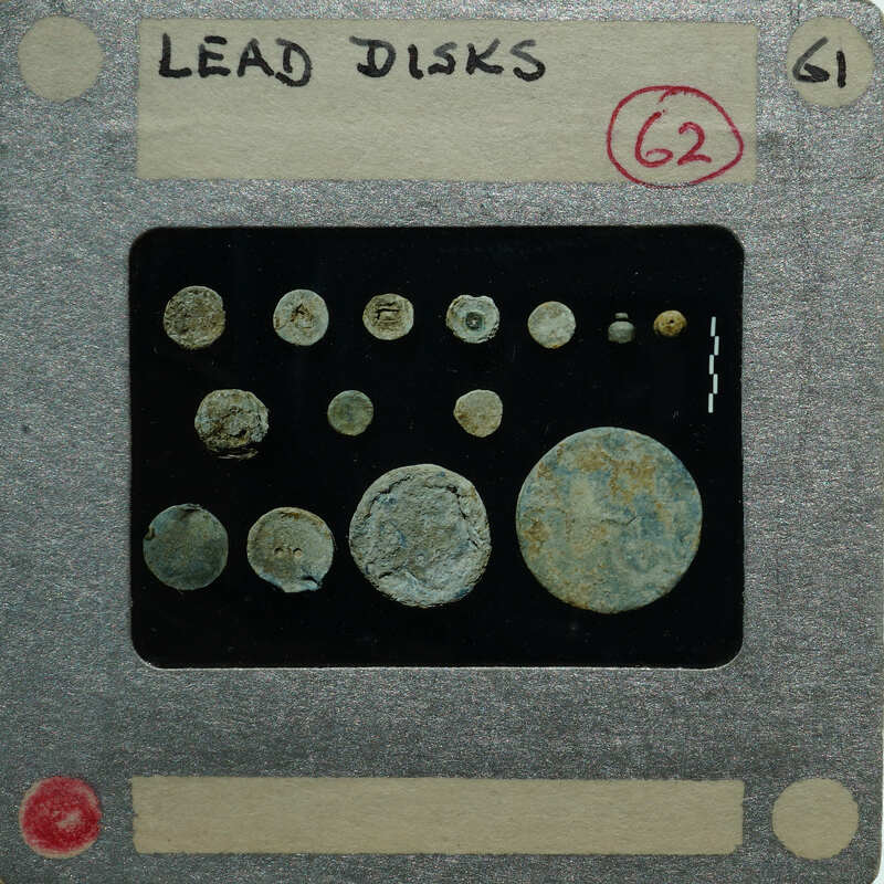 Collection of circular lead pieces on a display card.
