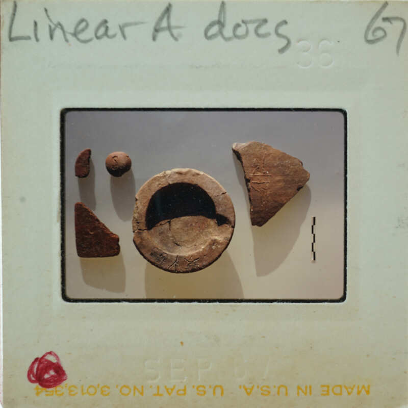 An image of a broken clay pot with fragments on display, taken from an old photograph.
