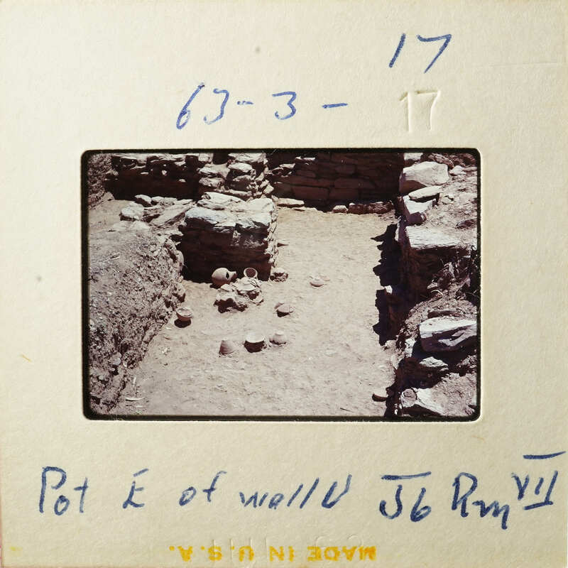 Ancient ruins with stone walls and scattered rocks, captured on an old photographic slide.