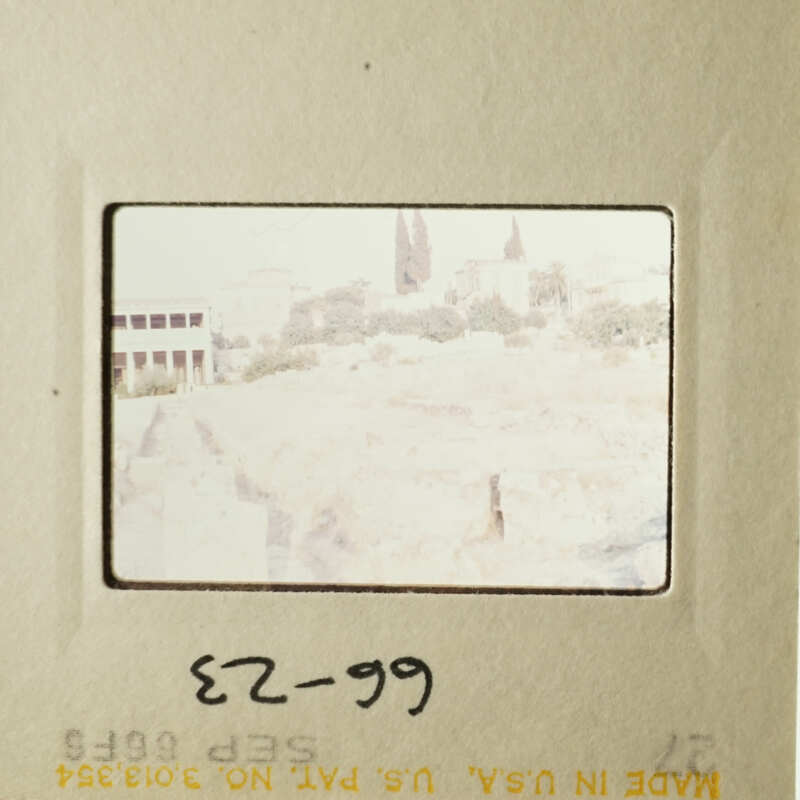 This is an image of a vintage photograph with a handwritten note on it, showing a cityscape and a building.