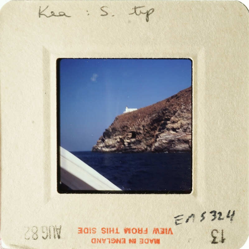 A photograph of cliffs and water with an ocean liner, taken from a boat.