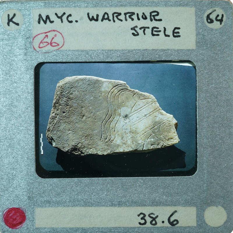 Flat stone fragment of marble with carving of man in helmet.