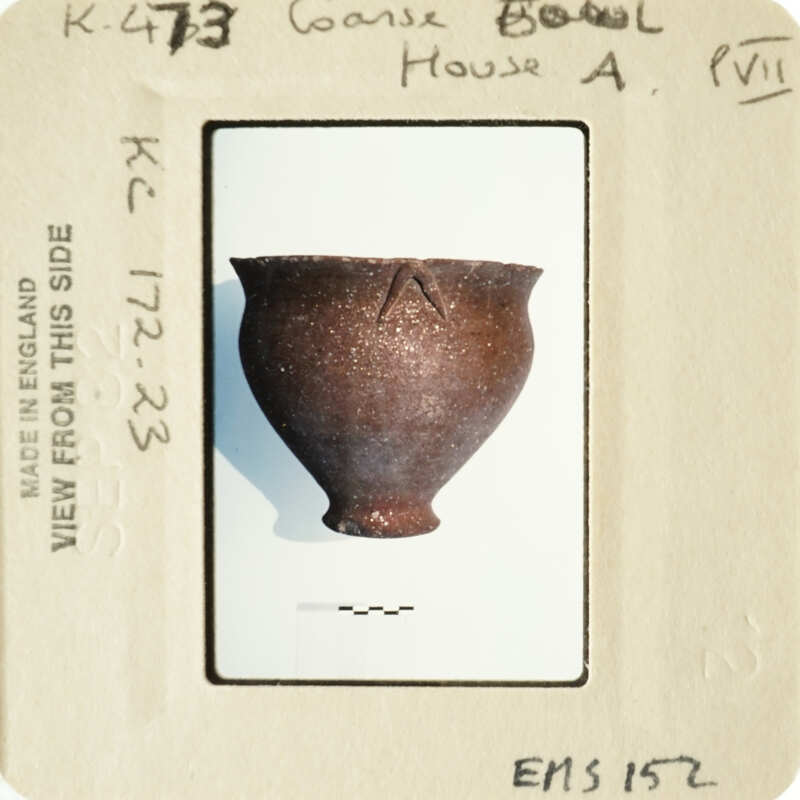 A photograph of an ancient clay pot with markings on its side.