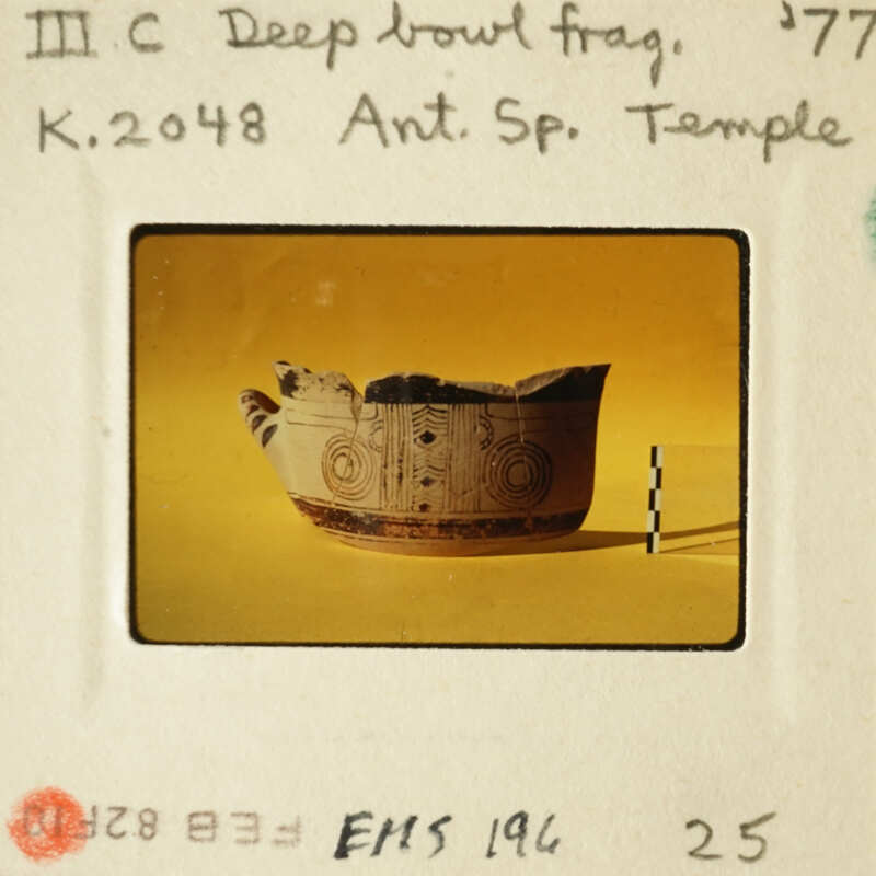 Ancient Greek vase with black and red designs on yellow background.