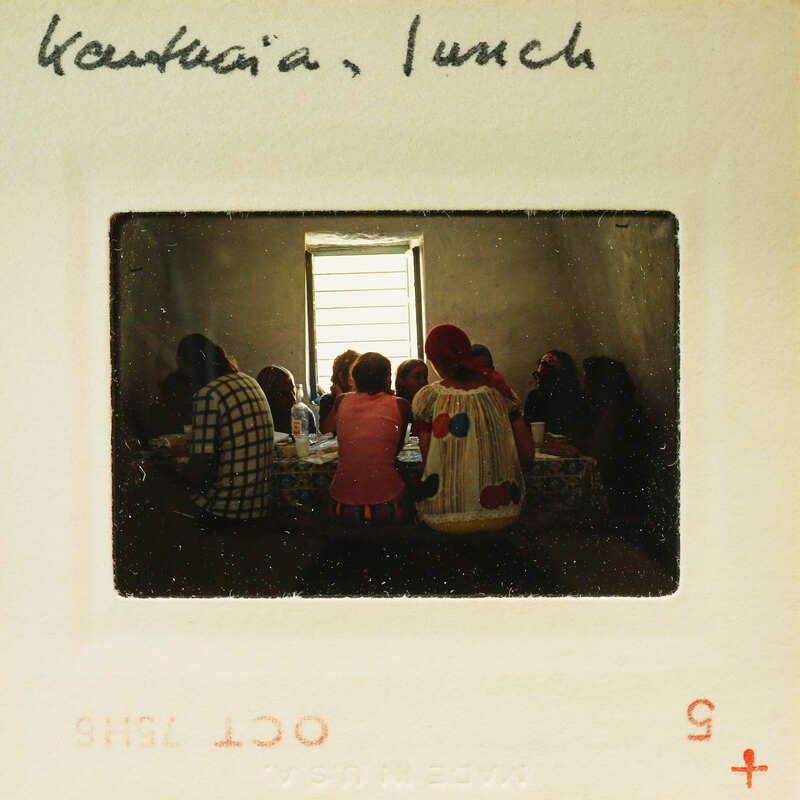 A group of people sitting around a table, possibly sharing a meal or engaging in conversation.