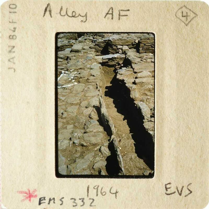 A photograph of an ancient stone structure with visible erosion and cracks.