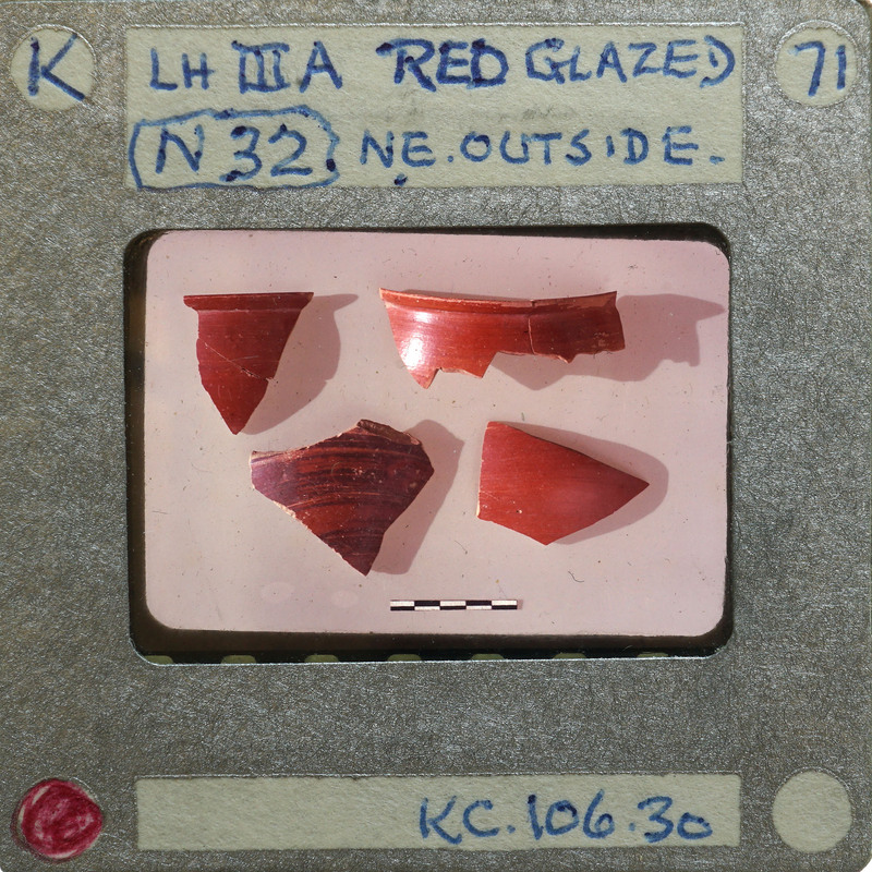 Four red glazed sherds on a white background.