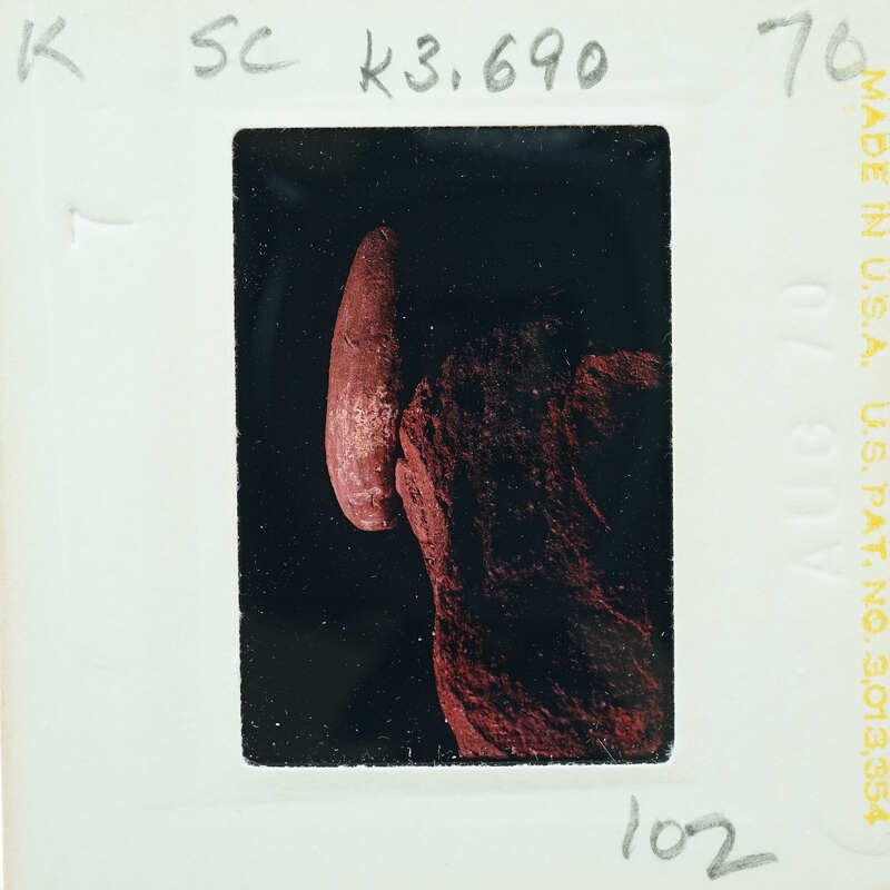 A photograph of a person's hand holding an object, with visible film strip details around the edges.