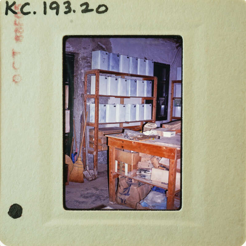 A photograph of a cluttered room with shelves and various items.