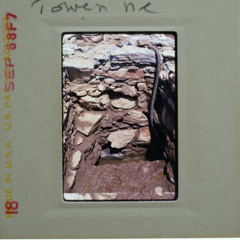 A photograph of a stone structure with visible damage, possibly from an explosion or natural disaster.