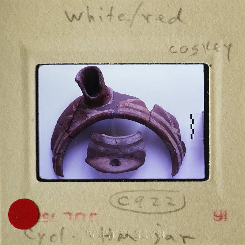 This is an image of a broken clay pot with visible cracks and chips, displayed on a white surface.