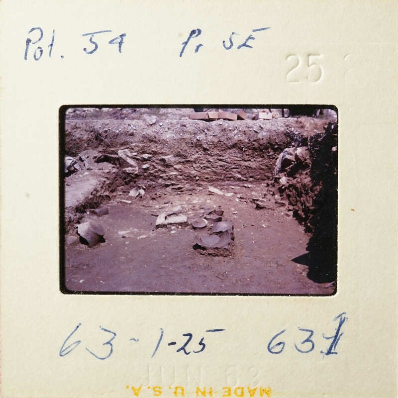 This is an old photograph showing a dirt path with rocks and debris.