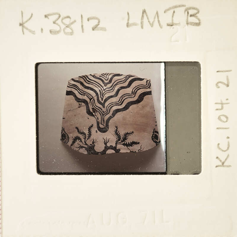 A small, intricately carved wooden object with a decorative pattern on it.