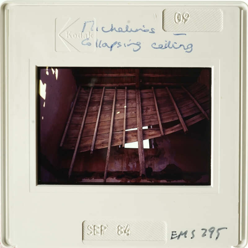 Old photo of an attic with exposed wooden beams and damaged ceiling.