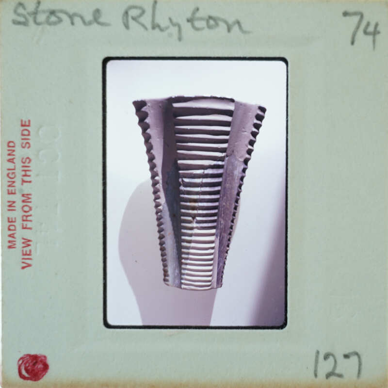 A close-up photograph of a metal object with ridges, possibly an antique or collectible item.