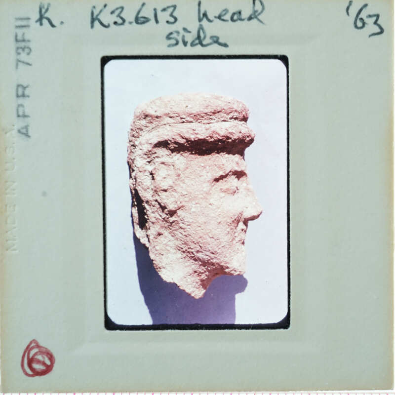 Terracotta face of figurine from side.