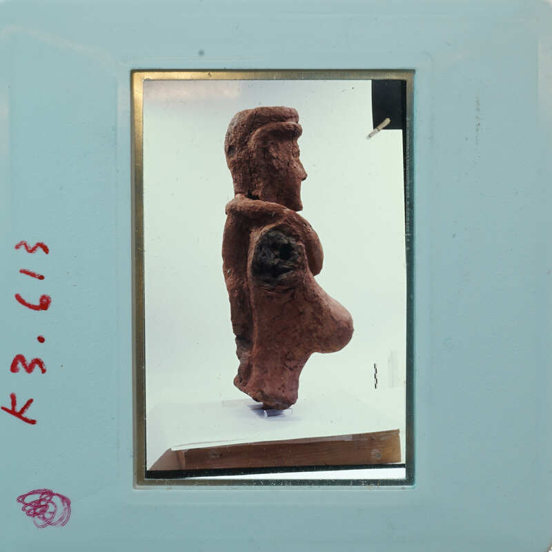 Terracotta figurine fragment (K3.613) from side showing head and torso.