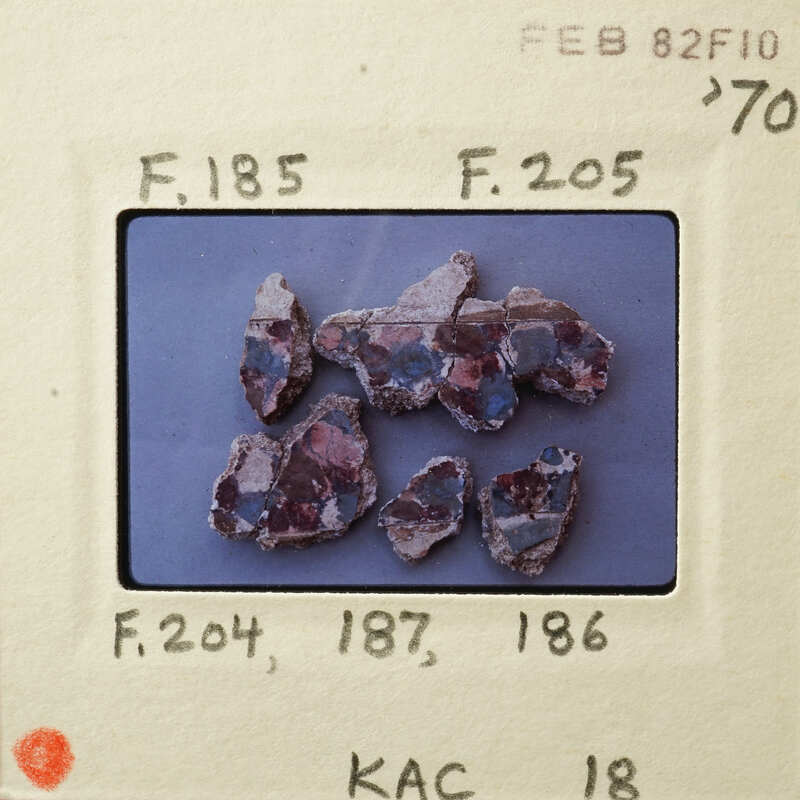 This is an image of small, colorful rocks on a white surface.