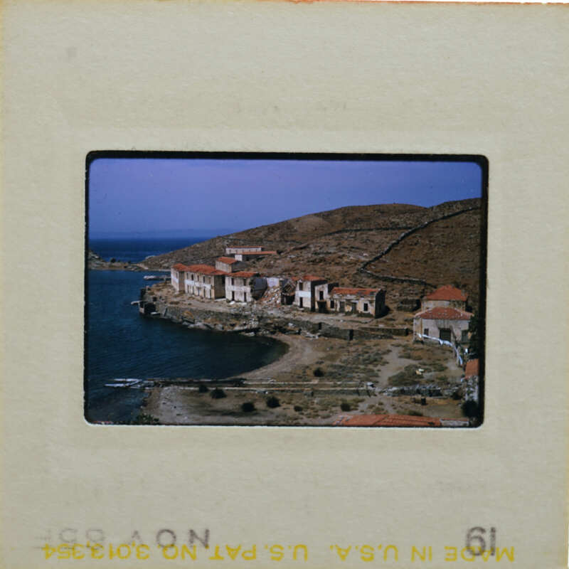 A slide showing a coastal village with buildings and water.