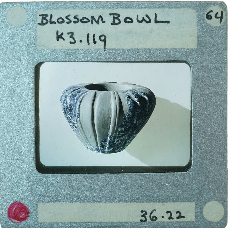 Small ceramic bowl with a rough, textured surface on display, K3.119.