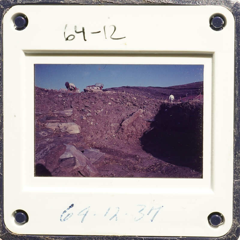 A photograph showing an outdoor scene with rocks and dirt, possibly indicating archaeological excavation work.