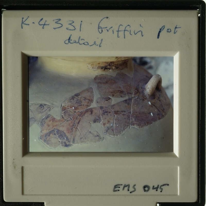 The image shows an ancient artifact with visible cracks and chips, possibly a pottery fragment.