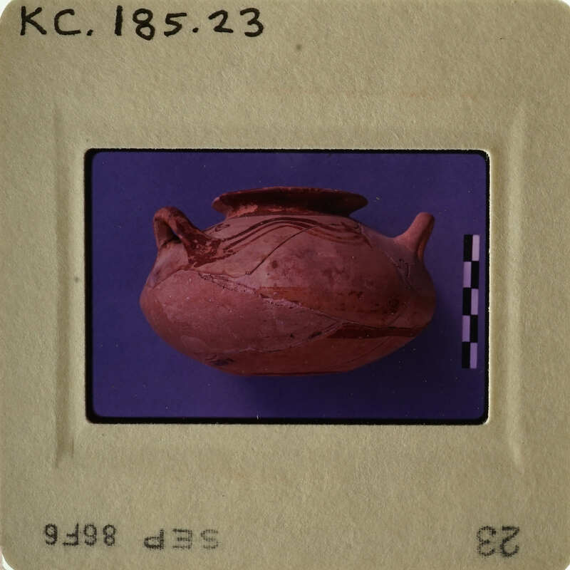 Ancient pottery vase with visible cracks and wear, displayed against purple background.