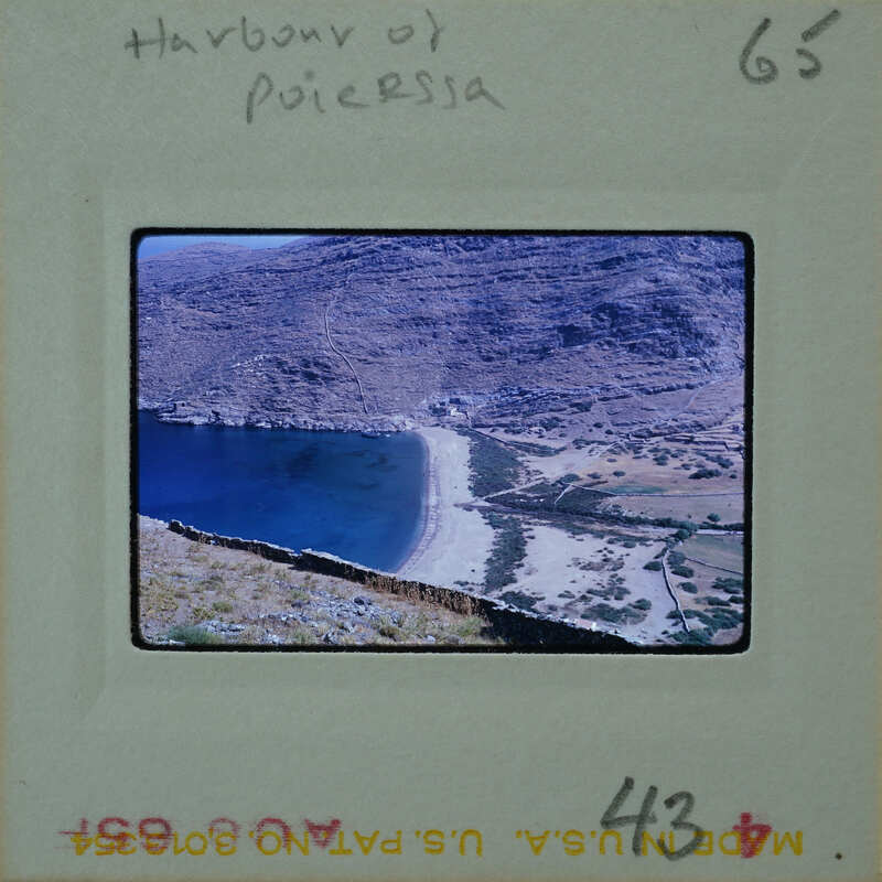 A vintage photograph of a scenic harbor with mountains, water, and vegetation.