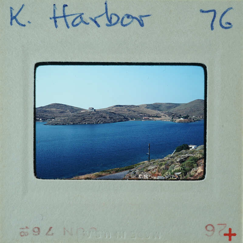 Picture of a harbor with water and mountains on a film strip.