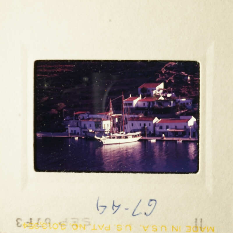 A colorful photo of a scenic coastal village with boats and houses by the water.