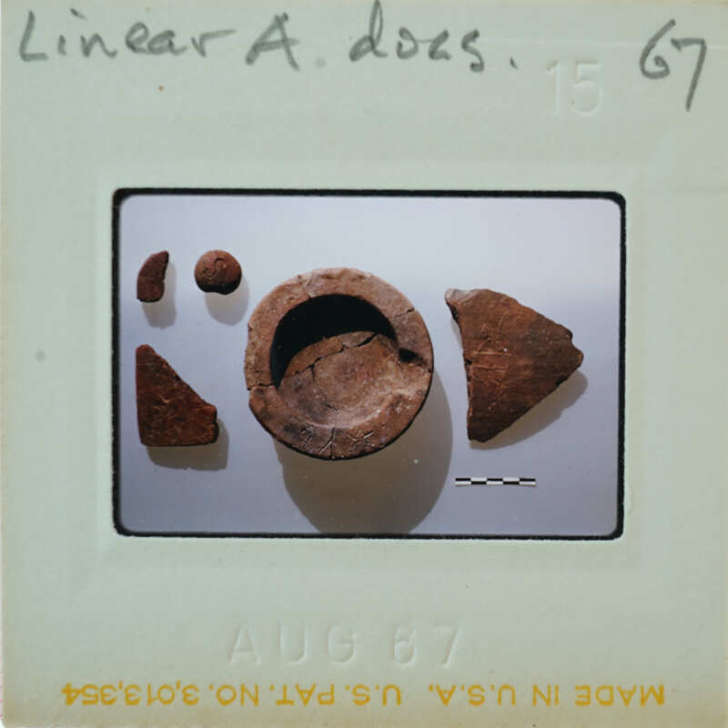 Photograph of a collection of ancient pottery shards and fragments on display.