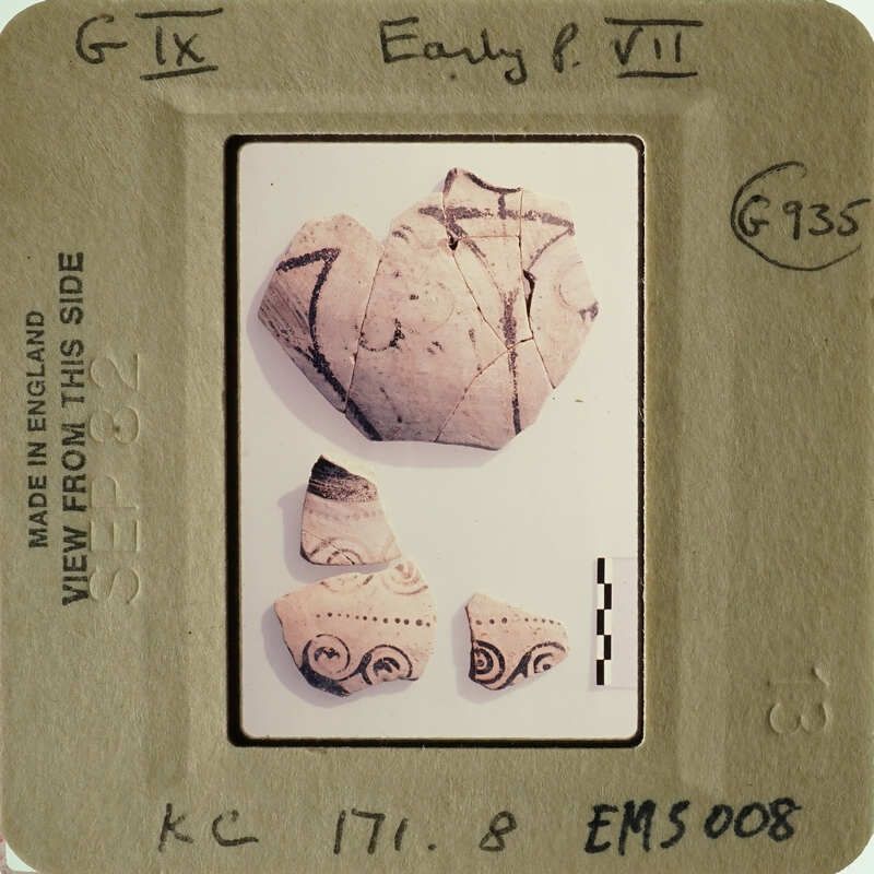 Photograph of ancient pottery with visible patterns and textures, including fragments.
