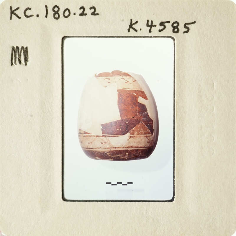 Ancient artifact with markings, possibly a clay pot or figurine.