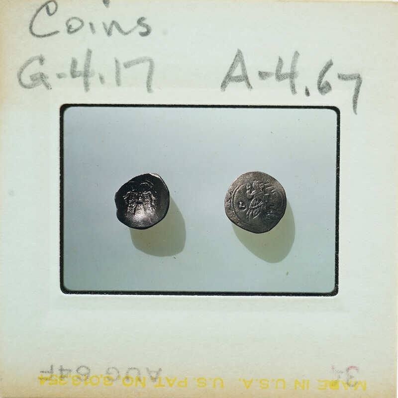 Two coins on a label with handwritten numbers and letters.