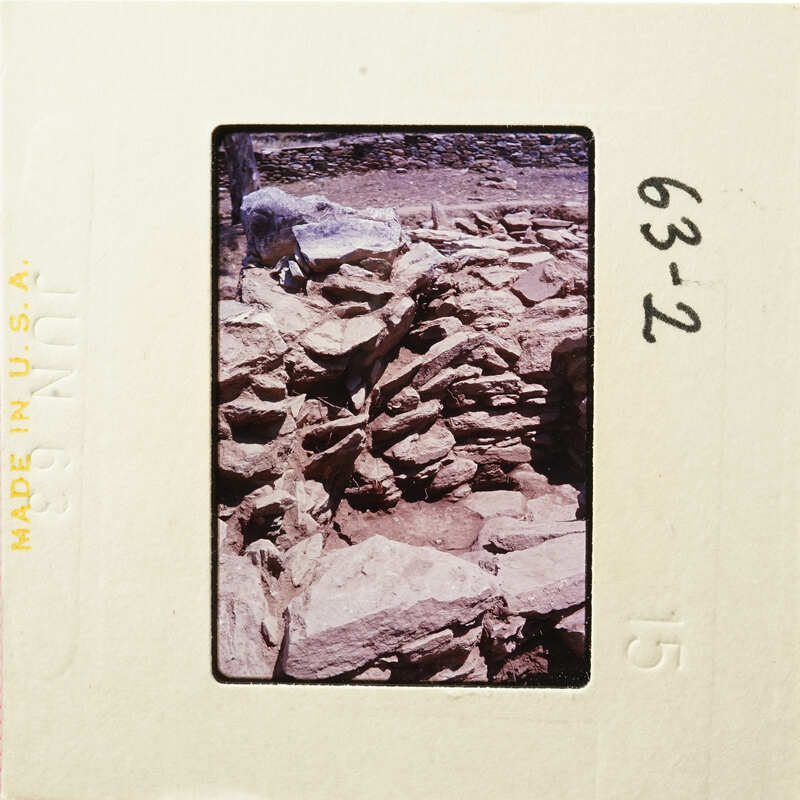 Old stone ruins with vegetation, captured on a vintage photographic slide.