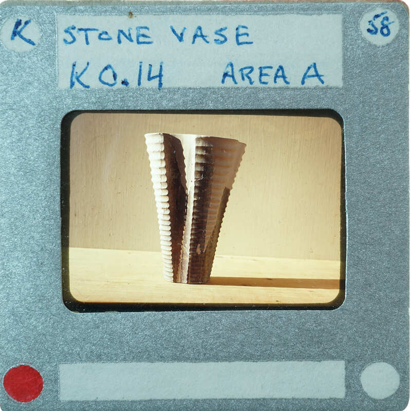 A photograph of a stone vase with a label indicating it is from area A and has the number K0.14.