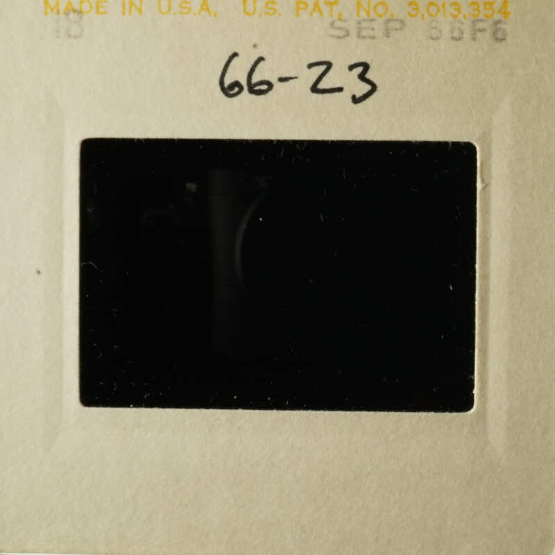 The image shows an old photograph with a black border and a handwritten note on the front, placed within a cardboard frame.