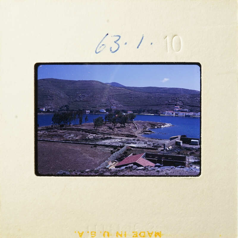 Aerial view of a coastal landscape with buildings and trees.