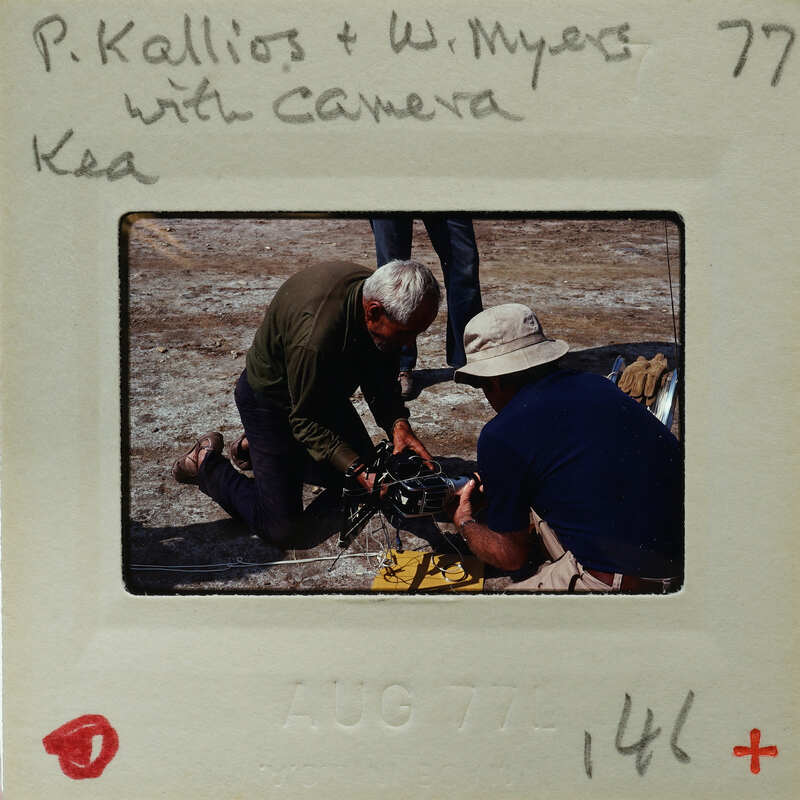 Two men working on a piece of equipment, possibly film or photography related.