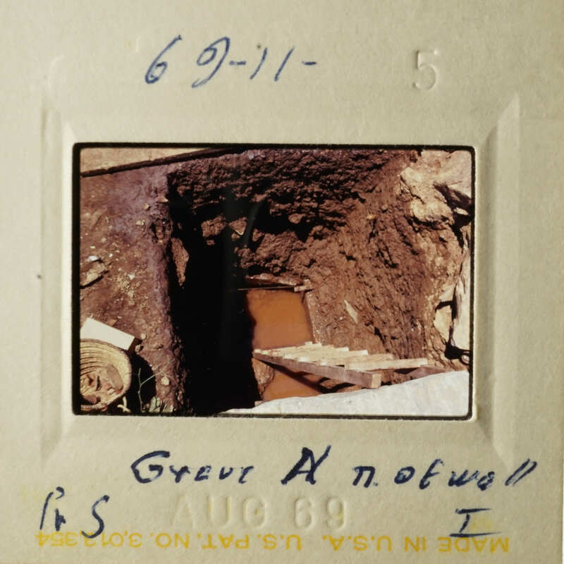 The image shows a vintage photograph of an old building, possibly a church, with a person standing outside.