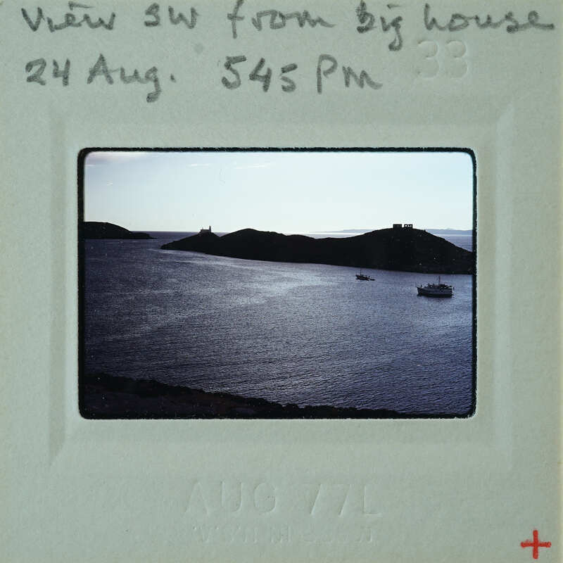 A photograph showing an island and body of water at sunset, with handwritten details on the border.