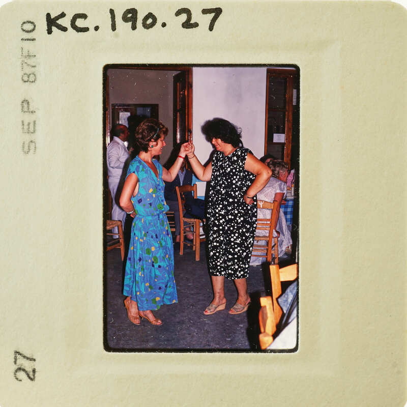Two women dancing together, with one giving a high five to the other. Catalog number KC.190.27