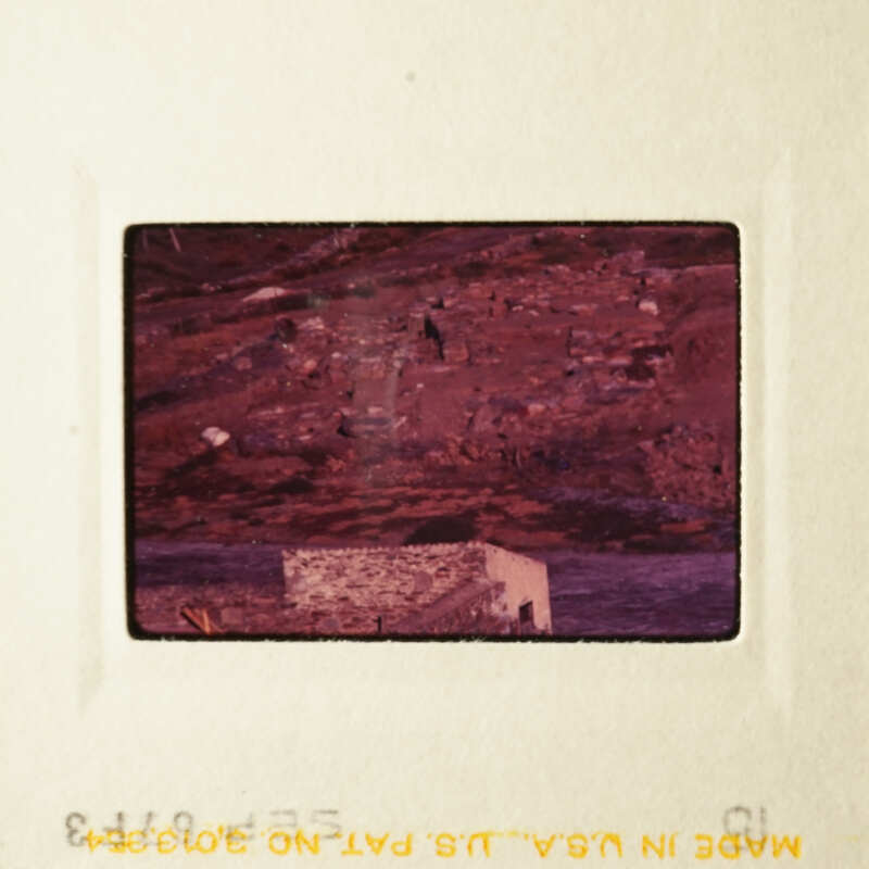 Slide with a photo of an abandoned building and a hillside.