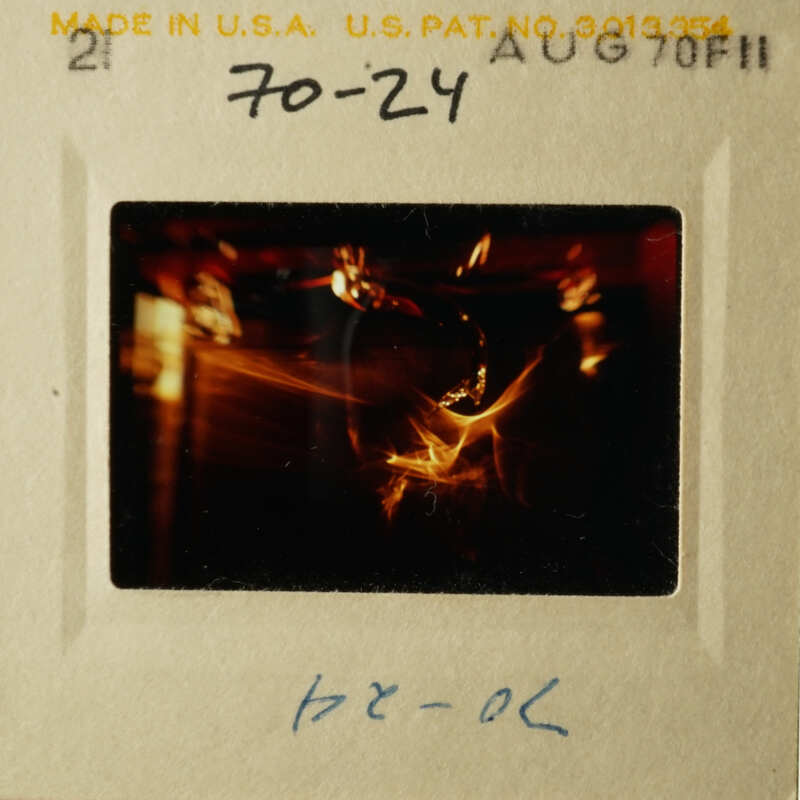 A black and white photograph of an older style film strip with a photo on it, featuring a blurry image of a candlelit scene.