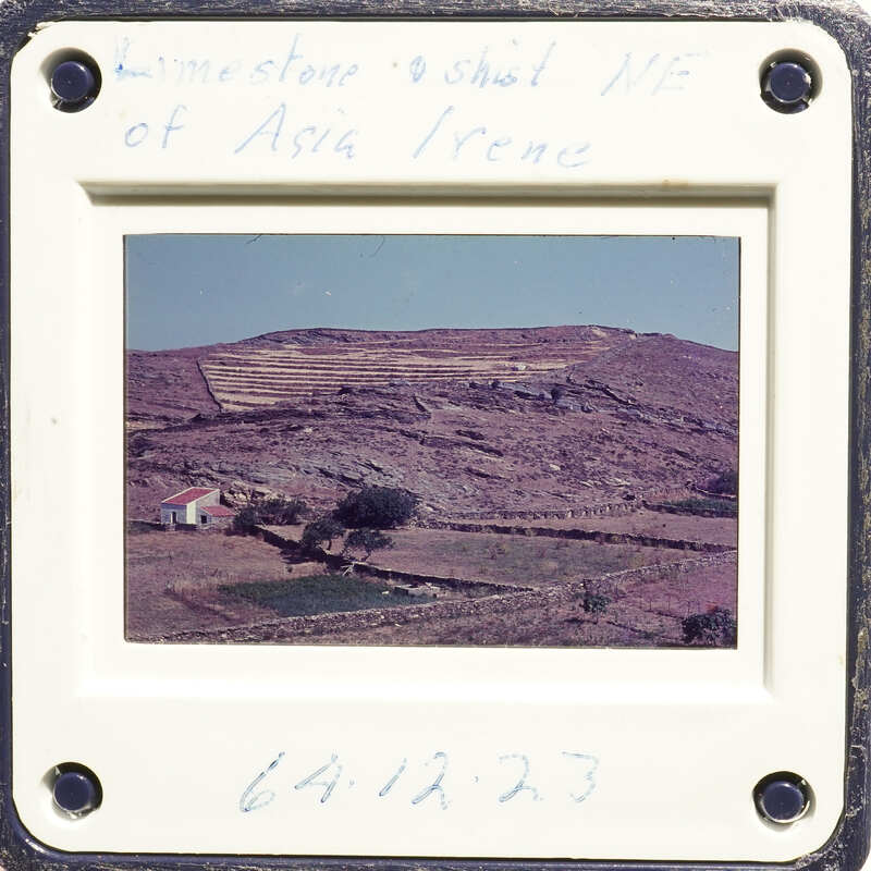 A photograph of a mountainous landscape with terraced fields and houses, taken from an elevated perspective.
