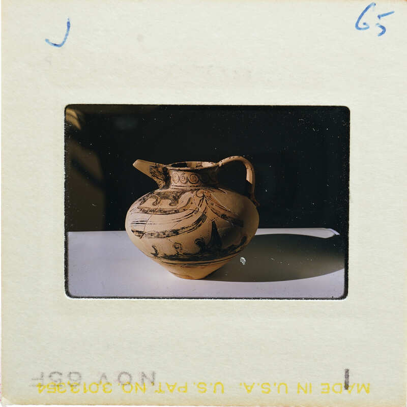 Profile image of a decorated jug with handle on a table.