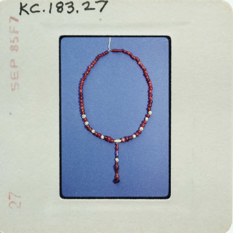 A string of red beads with a tassel hanging from it.