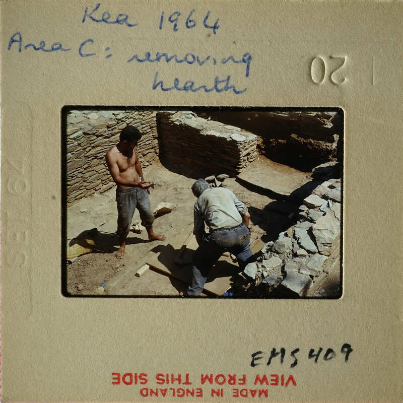 Two men working on stone ruins, possibly archaeologists or construction workers.