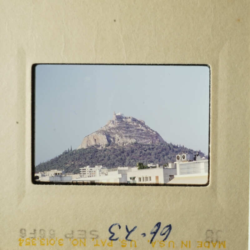 A view from above of a mountain with a city at its base.